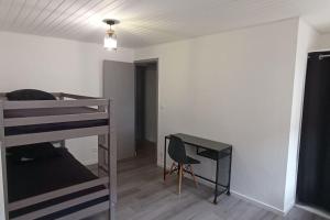 sypialnia z łóżkiem piętrowym i biurkiem w obiekcie Gîte les Rayols w mieście Saint-Agrève