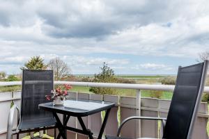 a table and chairs on a balcony with a view of the ocean at Straendhus Bed&Breakfast in Hasselberg