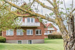 哈瑟尔贝格Straendhus Bed&Breakfast的红砖房子,设有白色阳台