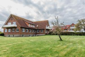 a large brick house with a tree in a field at Straendhus Bed&Breakfast in Hasselberg
