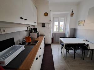 a kitchen with white cabinets and a table with chairs at Guest dAires in Coimbra