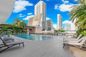 una piscina con tumbonas y edificios en Walk to the Waves, 2 Full Bed Beach Studio Stay, en Hallandale Beach