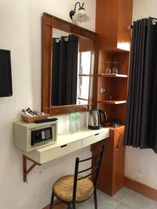 卡隆沙灘的住宿－KANWARA MASSAGE APARTMENT，厨房配有带微波炉的柜台和椅子