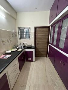 una cocina con armarios morados y una puerta morada en Furnished 3 BHK in Prime Location Near Arilova - 3rd Floor en Visakhapatnam