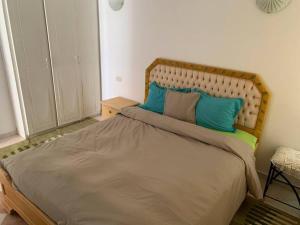 1 dormitorio con 1 cama grande con almohadas azules en Pleasant house in Africa Jade 200m to the beach, en Korba