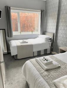 a bedroom with two beds and a window at The Cresswell Inn in Skegness