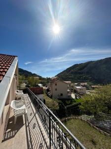 un balcón con una silla y el sol en el cielo en Apartment Perović, en Kotor