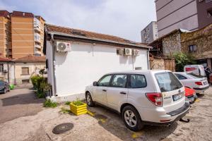 un coche aparcado en un aparcamiento al lado de un edificio en Paris Night en Niš