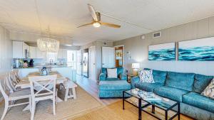 a living room with a blue couch and a table at IR104 3BR Condo w Gulf View, Shared Pools, Boardwalk in Port Aransas