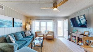 a living room with a blue couch and a tv at IR104 3BR Condo w Gulf View, Shared Pools, Boardwalk in Port Aransas