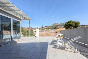 a patio with a bench on the side of a house at Livemalaga Pedregalejo in Málaga
