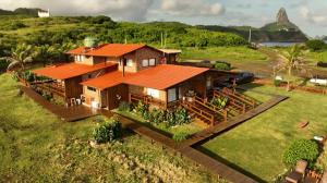 uma casa com um telhado laranja num campo verde em Pousada Naonda em Fernando de Noronha