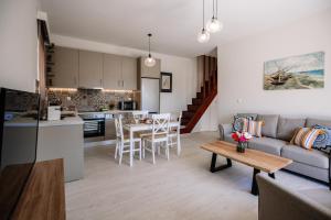 cocina y sala de estar con sofá y mesa en Melior Holiday Houses en Laganas
