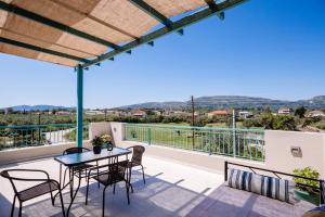 a balcony with a table and chairs and a view at Melior Holiday Houses in Laganas