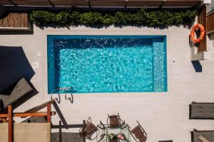a blue swimming pool on the side of a building at Melior Holiday Houses in Laganas