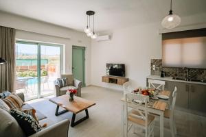 a living room with a couch and a table and a kitchen at Melior Holiday Houses in Laganas