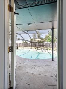 uma vista para uma piscina com um pátio aberto em Serenity Studio em Fort Pierce