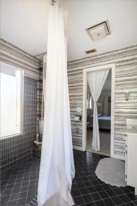 a bathroom with a white shower curtain and a bedroom at Serenity Studio in Fort Pierce
