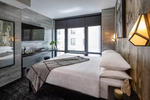 a bedroom with a large bed and a large window at The FIDI Hotel in New York