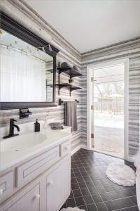 ein Badezimmer mit einem Waschbecken und einem großen Fenster in der Unterkunft Serenity Studio in Fort Pierce