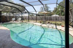 uma grande piscina com uma pérgula ao lado de uma piscina em Serenity Studio em Fort Pierce