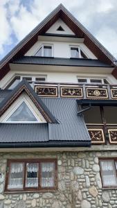 uma casa com telhado de metal e janelas em Stary Bór em Murzasichle