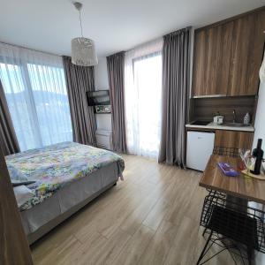 a bedroom with a bed and a table and a kitchen at Apartmani Port in Bar