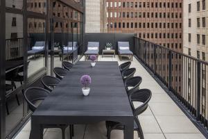 una mesa negra y sillas en el balcón en The FIDI Hotel en Nueva York