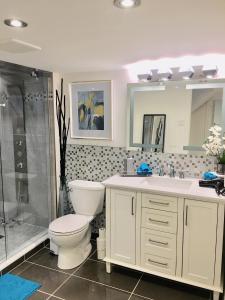 uma casa de banho com um WC, um lavatório e um chuveiro em Luxury Bachelor Suite em Pointe-Claire