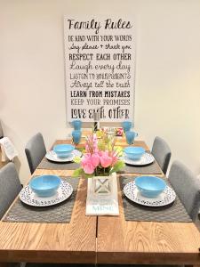 una mesa de madera con platos azules y un jarrón de flores en Luxury Bachelor Suite, en Pointe-Claire