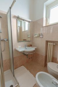 a bathroom with a sink and a toilet and a shower at Hotel Tritone in Senigallia +62 photos
