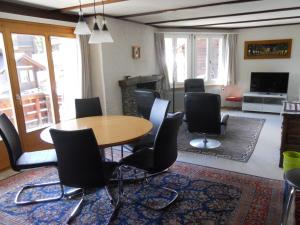 Zimmer mit einem Tisch, Stühlen und einem Kamin in der Unterkunft Chalet Anemone 2 in Mürren