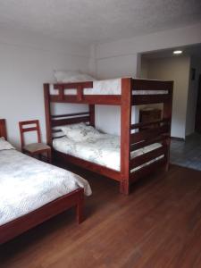 Hospedaje Familiar في كوينكا: سريرين بطابقين في غرفة مع أرضيات خشبية