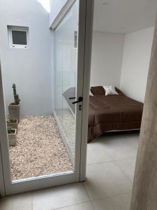 聖佩德羅的住宿－Estudio，滑动玻璃门通向卧室(带床)