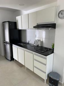 聖佩德羅的住宿－Estudio，厨房配有白色橱柜和黑色冰箱。