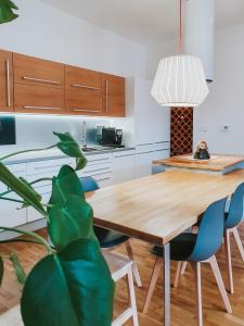 a kitchen with a wooden table and blue chairs at Priestranný apartmán v centre in Košice