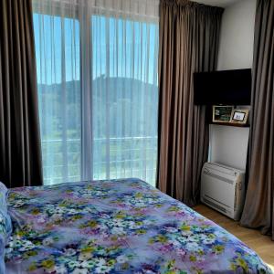 a bedroom with a bed and a large window at Apartmani Port in Bar