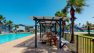 a pavilion with benches next to a swimming pool at SIV10 Beautiful Condo, Shared Pool, Close to Beach in Port Aransas