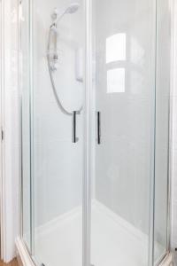 a shower with a glass door in a bathroom at Seabrin in Aberystwyth