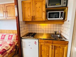 eine kleine Küche mit einer Spüle und einer Mikrowelle in der Unterkunft Studio Hauteluce, 2 pièces, 4 personnes - FR-1-293-218 in Hauteluce