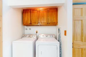 een keuken met houten kasten en een wasmachine en droger bij Wapiti Point - Main House in Grand Lake