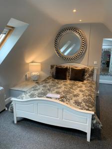 a bedroom with a bed with a mirror on the wall at The Coquet Apartment - short stroll to Warkworth Castle and Hermitage in Warkworth