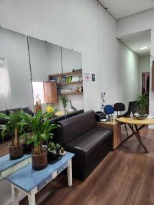 uma sala de estar com um sofá e uma mesa com vasos de plantas em Fujima Hostel em São Paulo