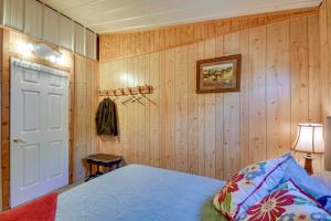 a bedroom with wooden walls and a bed and a door at Crowell Cabin about 9 Mi to Copper Breaks State Park! 
