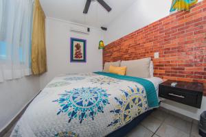 a bedroom with a bed and a brick wall at Hotel Suites Nadia Puerto Vallarta in Puerto Vallarta