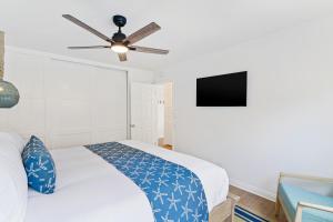 a bedroom with a bed and a ceiling fan at Palm Tree Oasis in Newport Beach