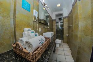 a bathroom with a basket of towels and a toilet at Hotel Suites Nadia Puerto Vallarta in Puerto Vallarta