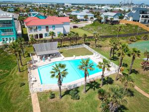 an aerial view of a house with a pool and palm trees at IR145 2nd Floor Condo, Ocean View, 1 Bedroom, Shared Pools, Boardwalks in Port Aransas