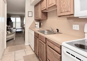 a kitchen with wooden cabinets and a sink at IR149 2nd Floor Studio Condo with Gulf View, Shared Pools, Boardwalks in Port Aransas