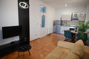 a living room with a couch and a kitchen at Apartman Tena in Vukovar